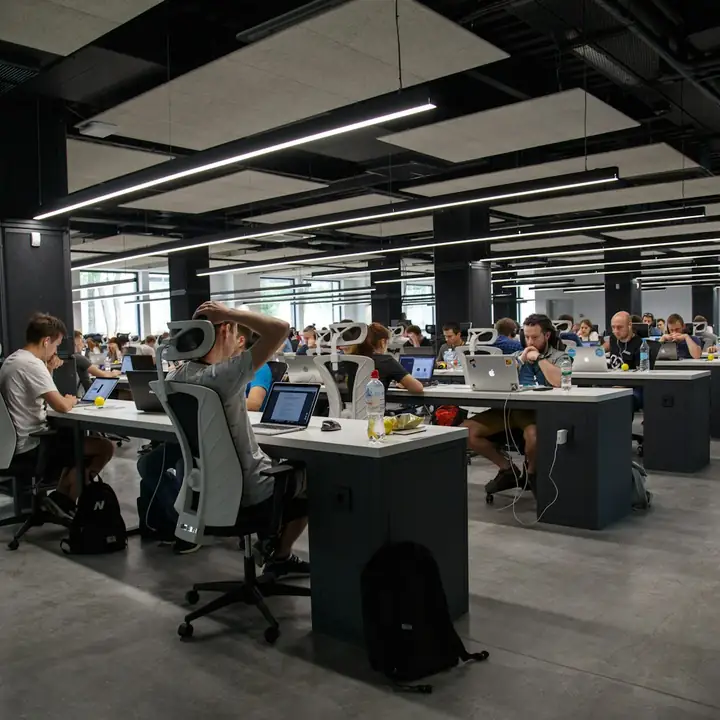 Un grande open space con persone al lavoro alle scrivanie